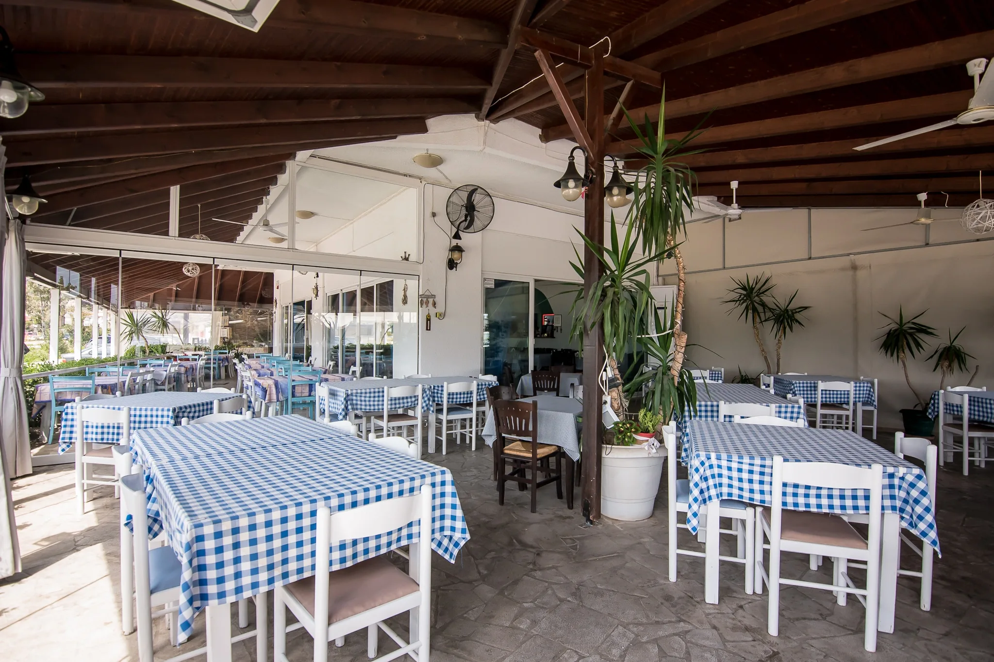 The covered dining area with its blue-checked tables